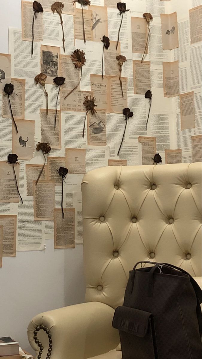 a chair sitting in front of a wall with flowers on it and many other pieces of paper attached to the wall