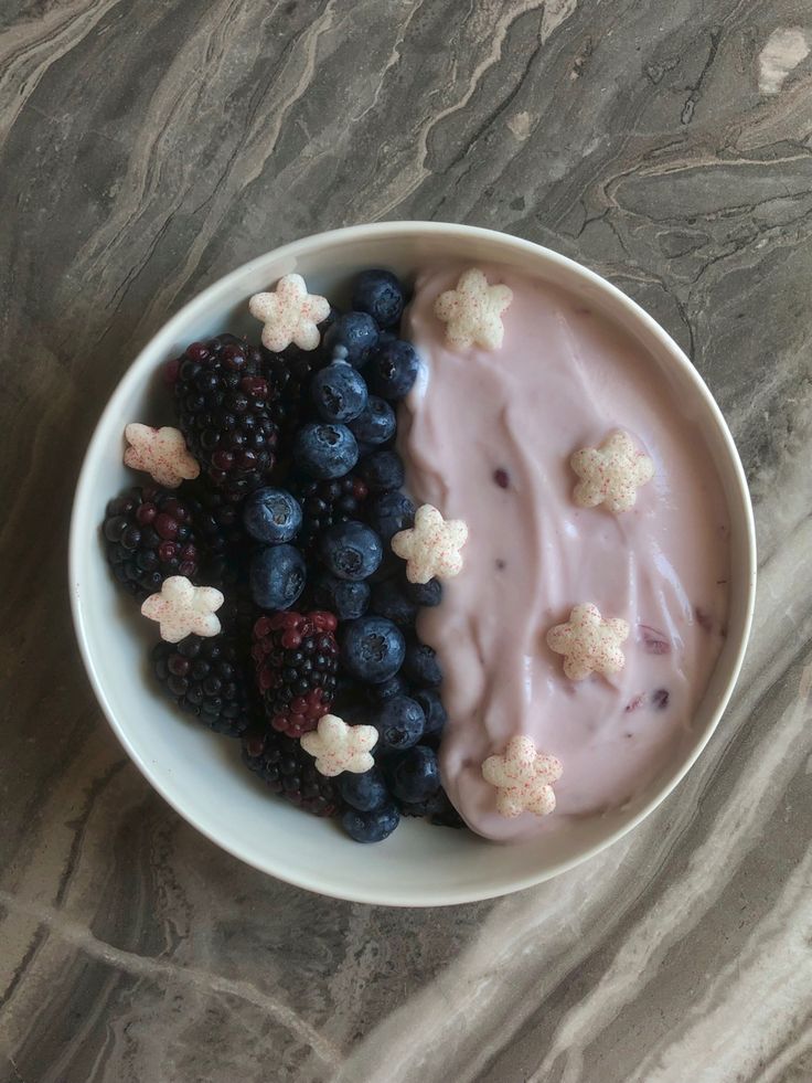 a bowl filled with fruit and cereal on top of a table