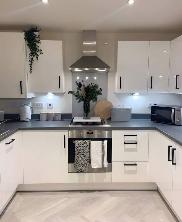 a kitchen with white cabinets and stainless steel appliances in the center, along with an oven