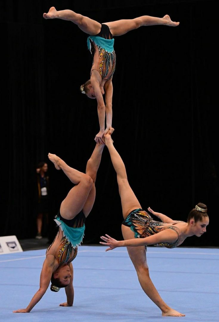 three women doing acrobatic tricks on the floor