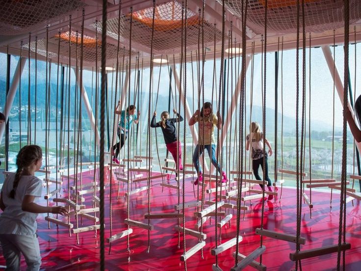 a group of people standing on top of ropes in a room with red flooring