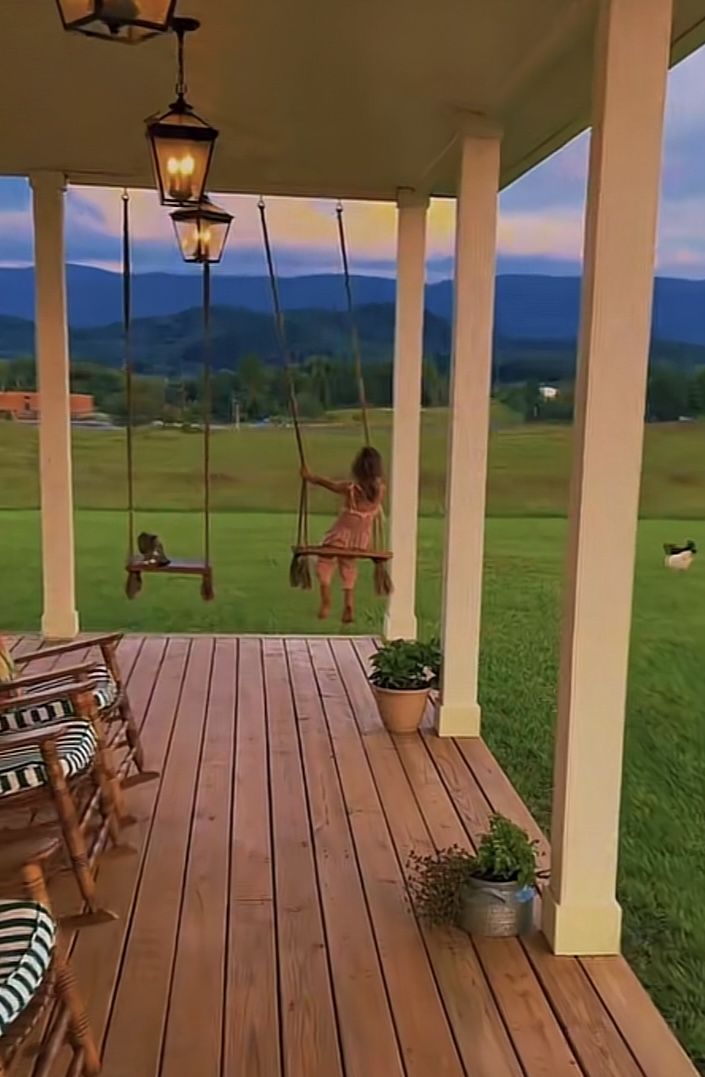 a woman sitting on a porch swing in the evening