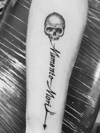 a black and white photo of a person's arm with a skull on it