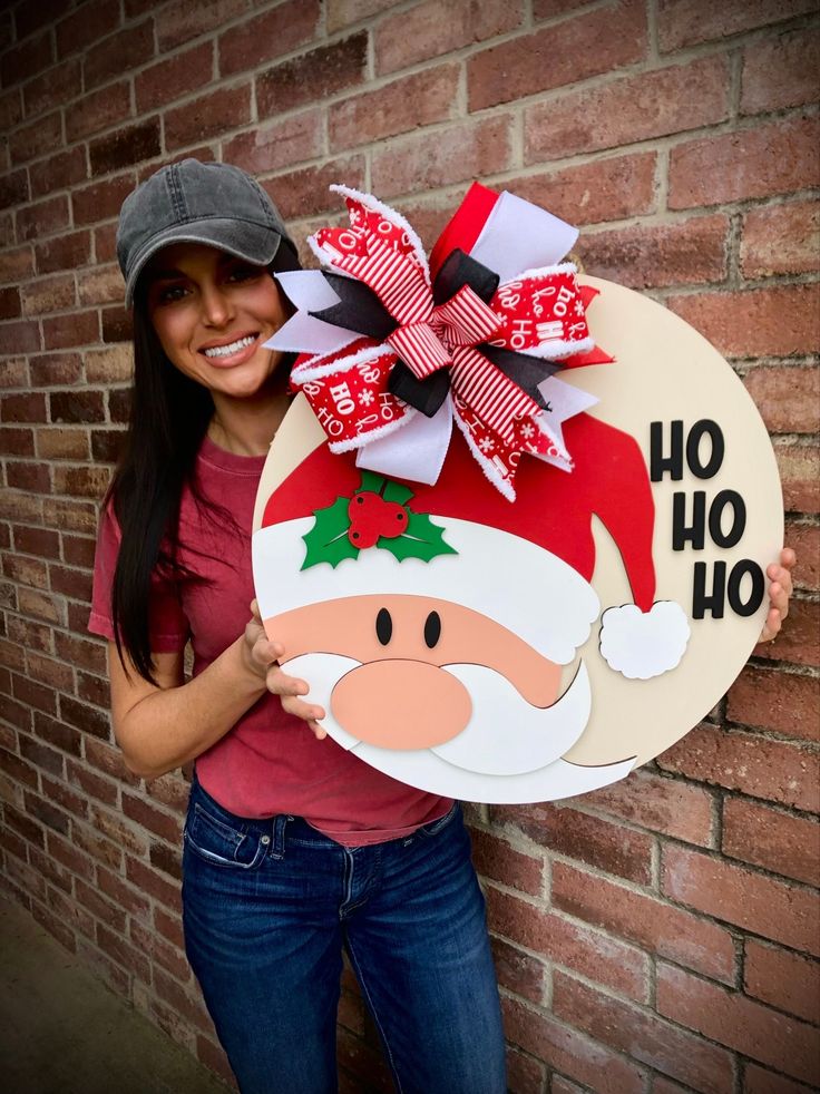 a woman holding up a sign with santa clause on it