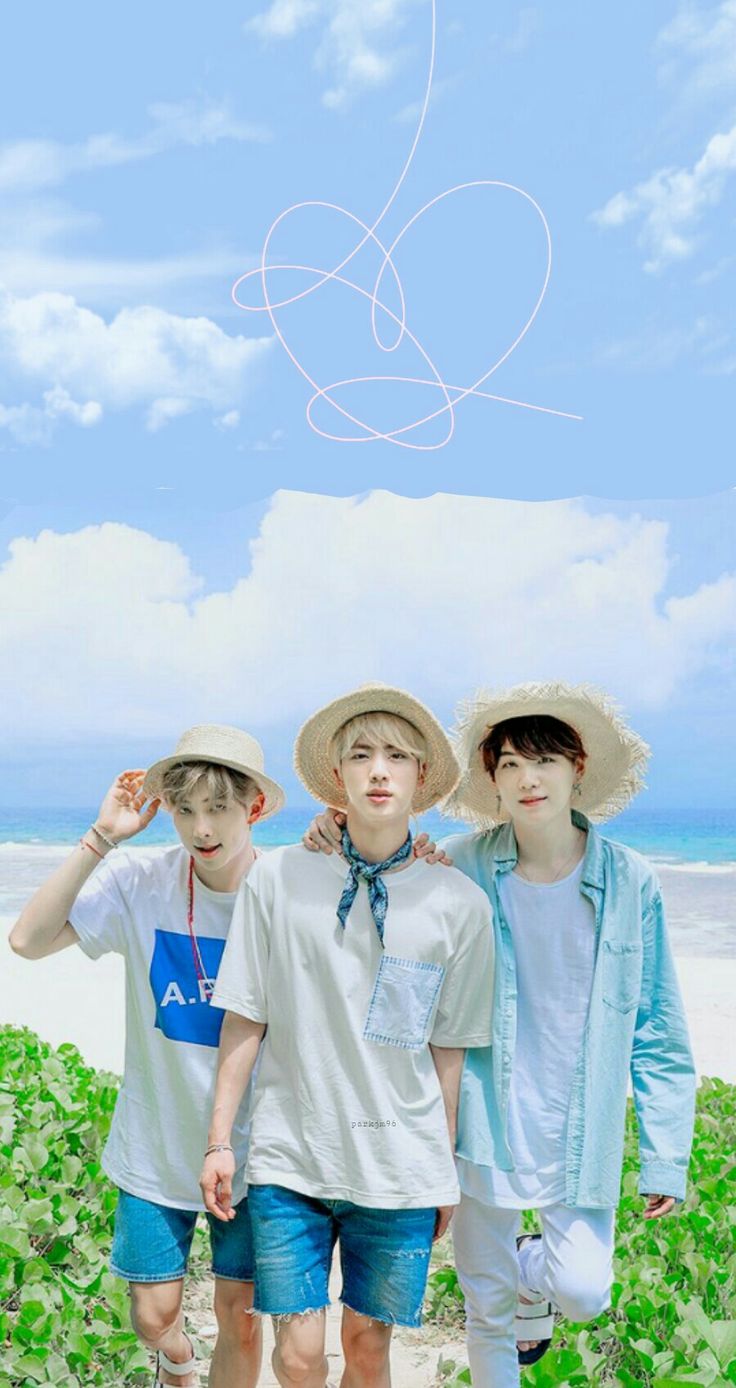 three young boys standing on the beach with their arms around each other