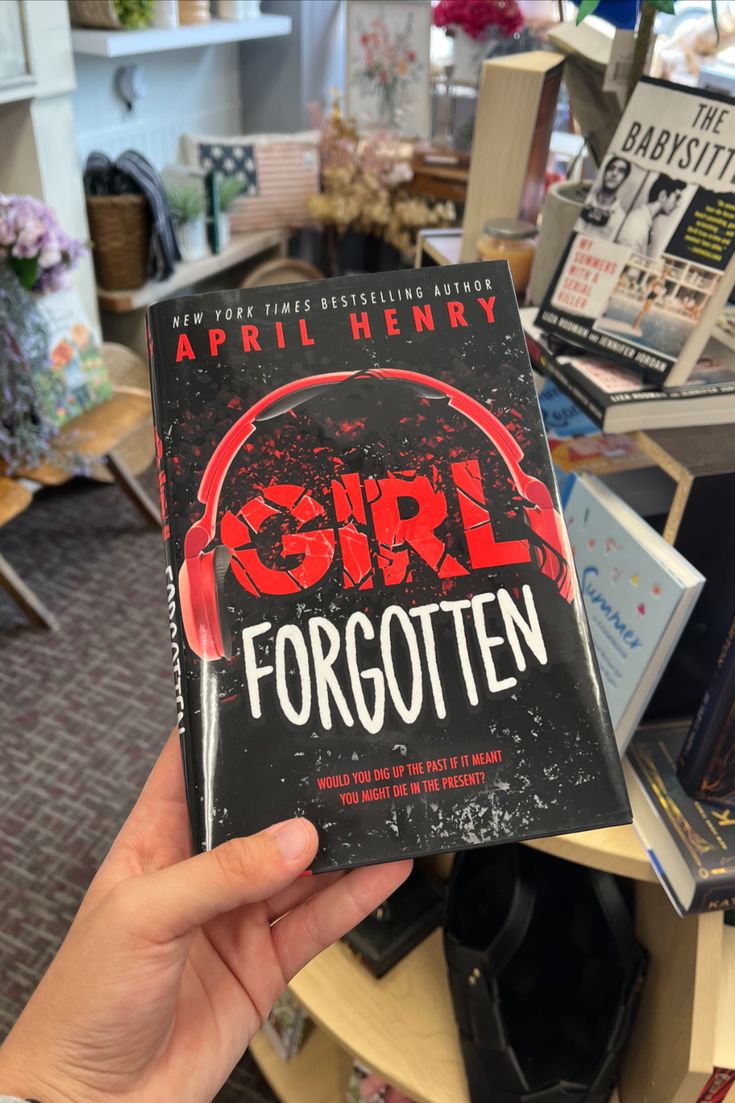 a person holding up a book about girl forgotten