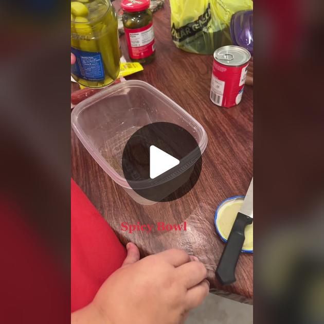 a person is cutting something with a knife on a wooden table in front of other food items