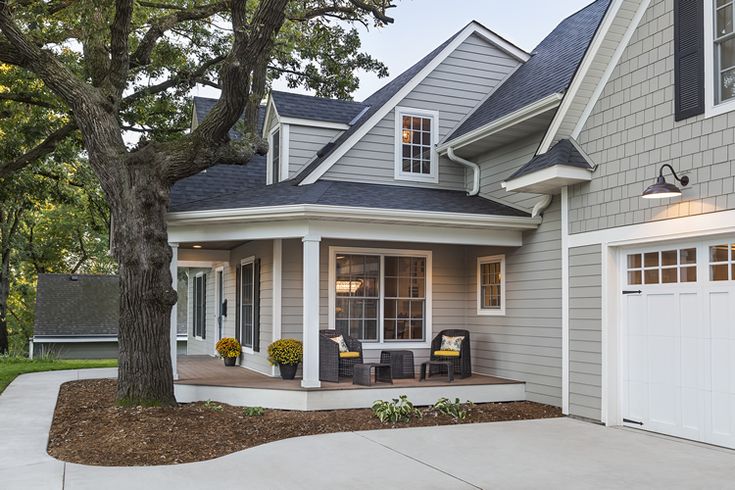 a gray house with white trim and two car garages on the front porch area