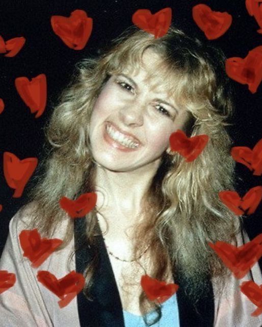 a woman with long blonde hair surrounded by red hearts