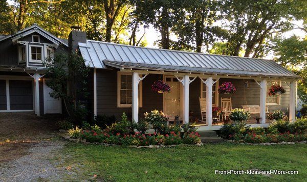 a small brown house with white trim and metal roof