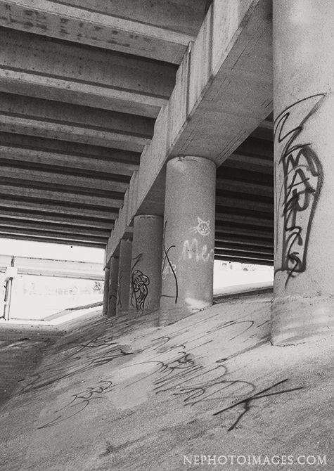 black and white photograph of graffiti under an overpass