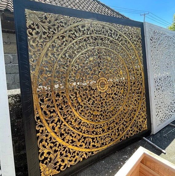 an intricately designed metal screen on the side of a building in front of a house