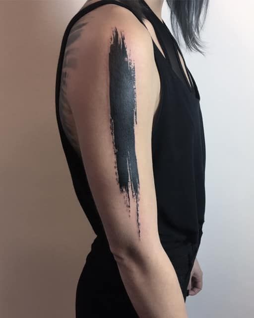 a woman with black hair has a tattoo on her arm