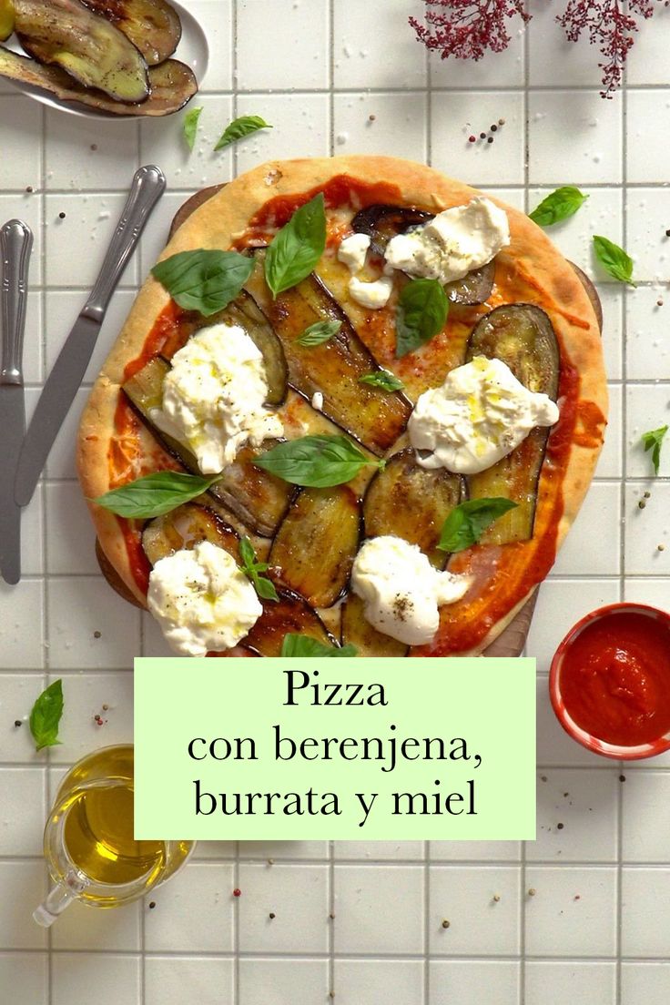 an overhead view of a pizza on a table with other dishes and utensils