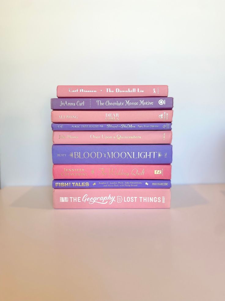 a stack of books sitting on top of a wooden table