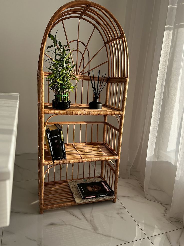 a bamboo shelf with plants and books on it