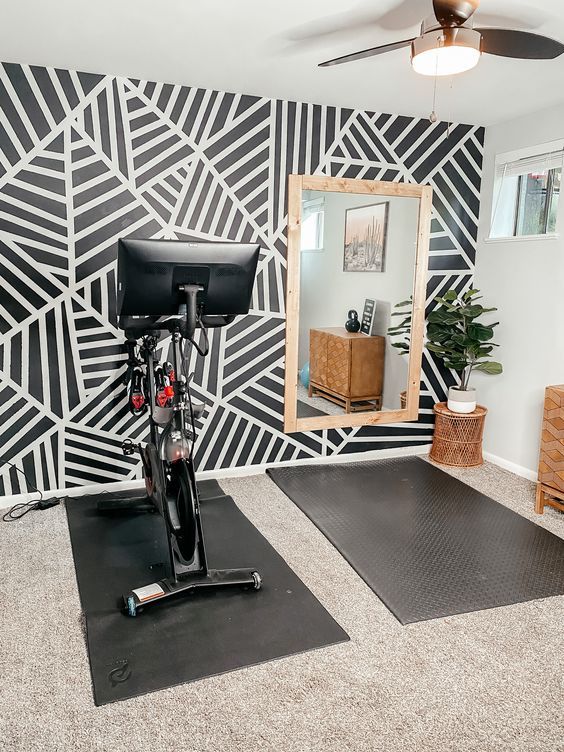 a bike is parked in front of a mirror on the floor next to a mat