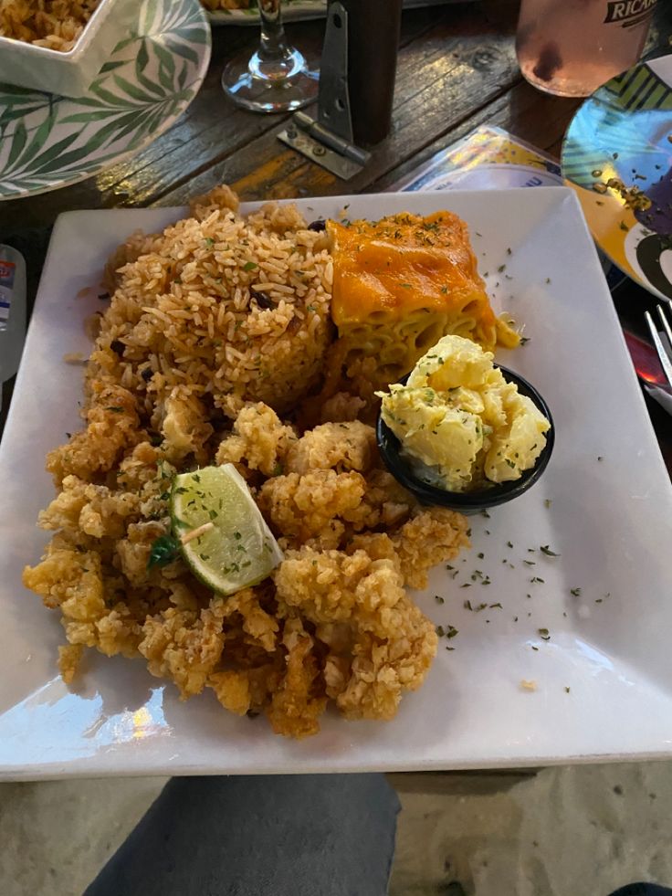 a white plate topped with fried food on top of a table