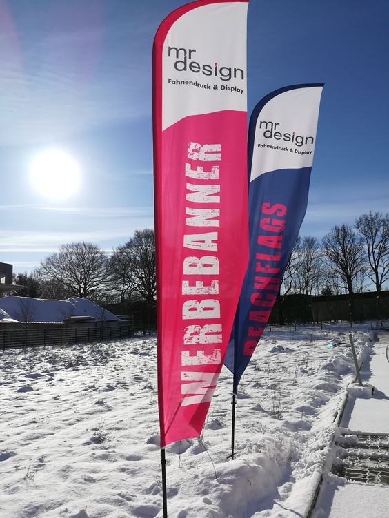 two flags in the snow on a sunny day