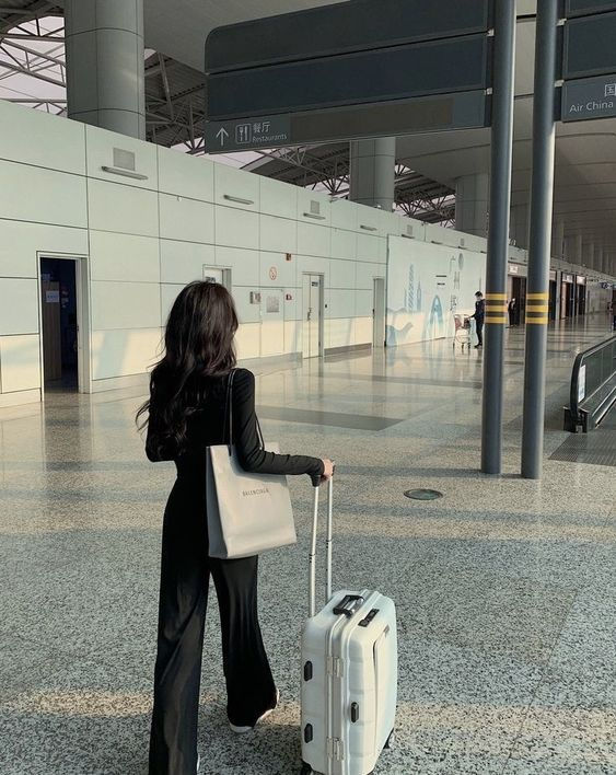 a woman with a suitcase in an airport