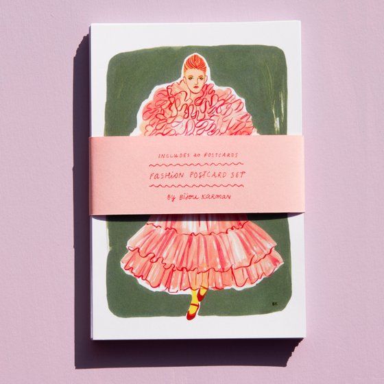 a card with a drawing of a woman in a pink dress on top of it