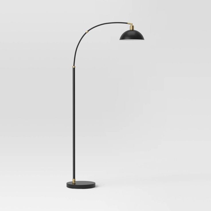 a black and gold floor lamp on a white background