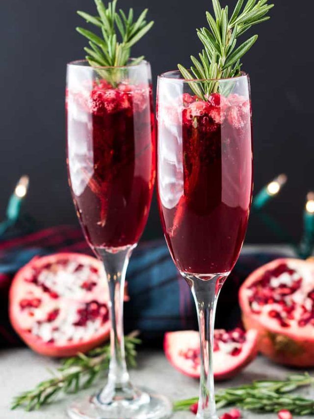 two glasses filled with pomegranate and garnished with rosemary