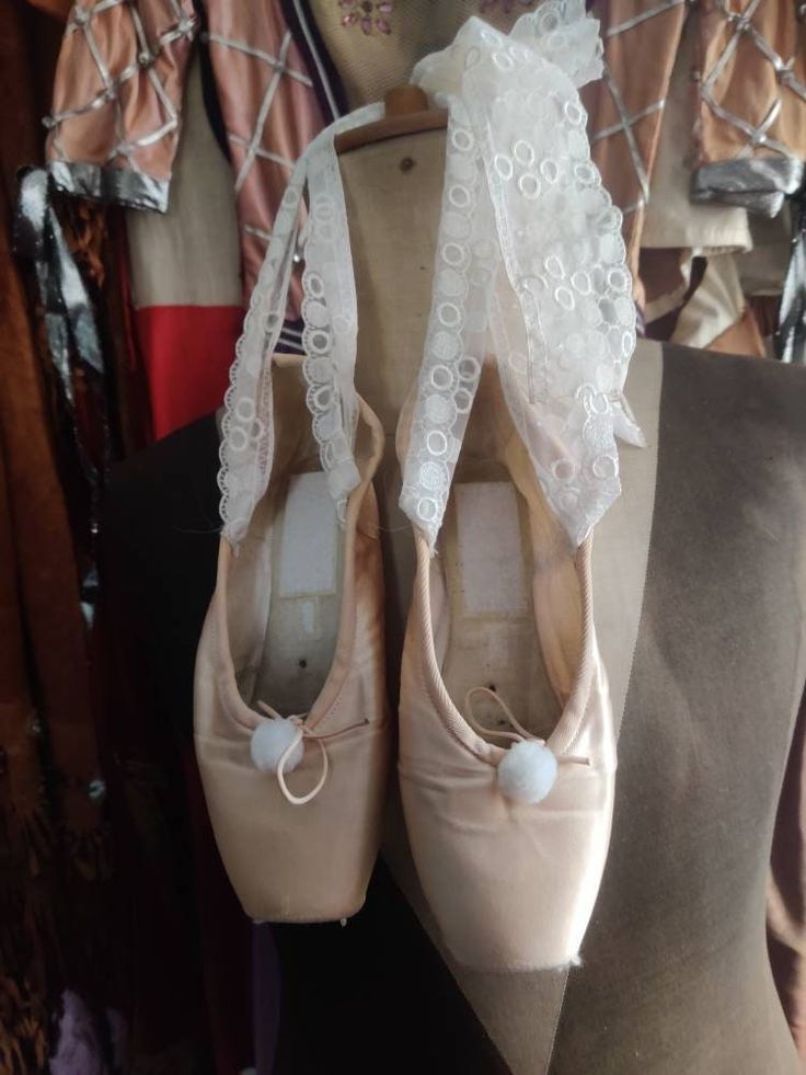 two pairs of ballet shoes with lace on them