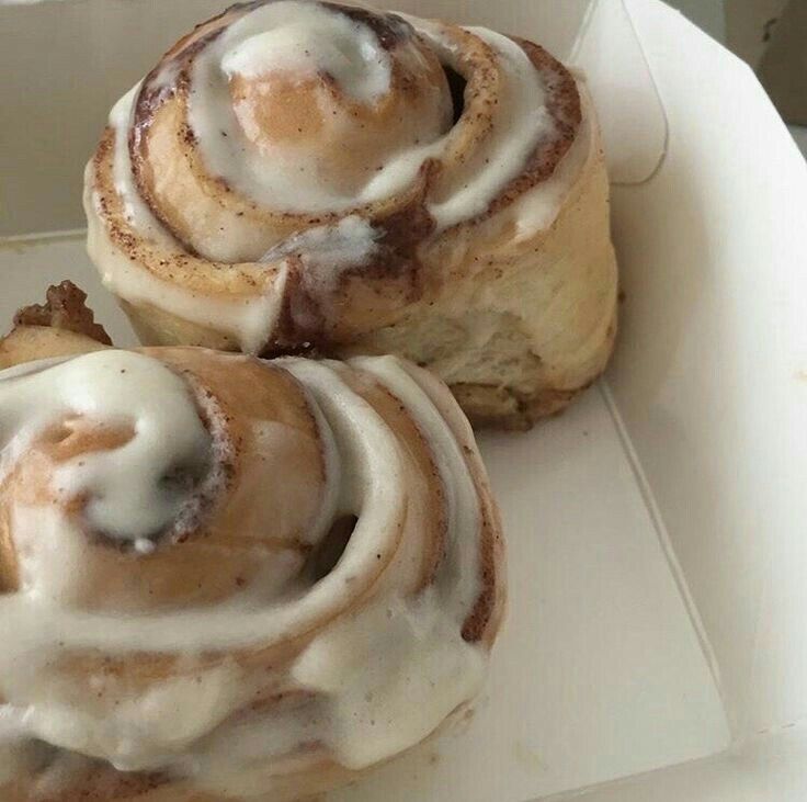 two cinnamon rolls sitting in a white box