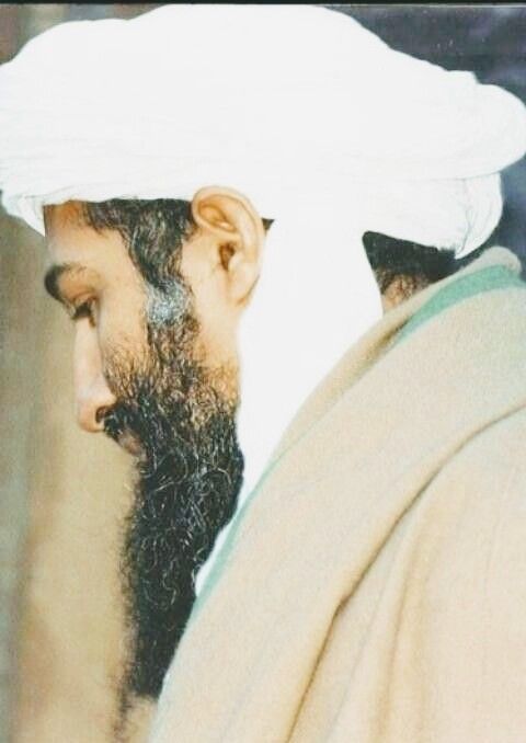 an old photograph of a man wearing a white turban and looking at something