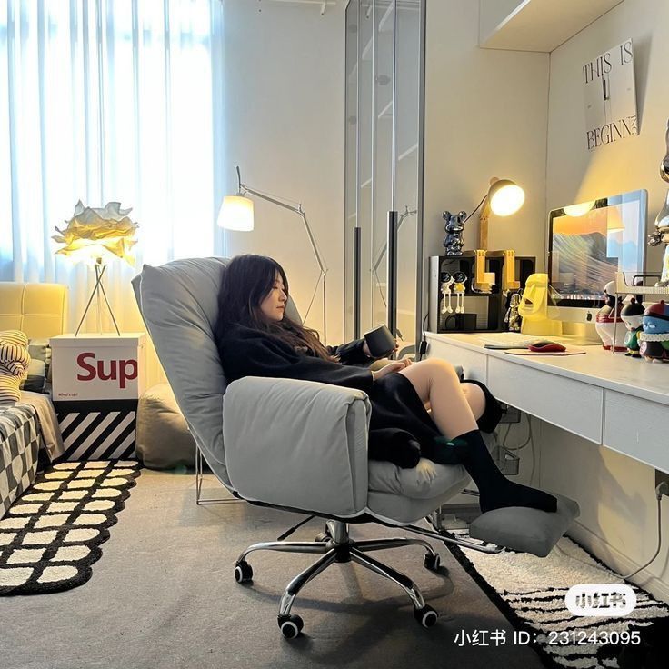 a woman sitting in a chair next to a desk