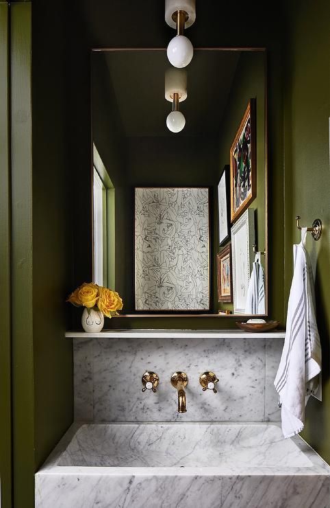 a white sink sitting under a mirror in a bathroom next to a wall mounted faucet