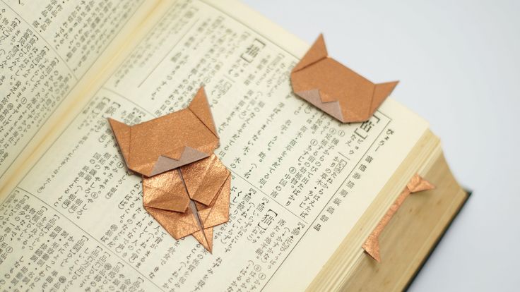 an open book with origami cats on it