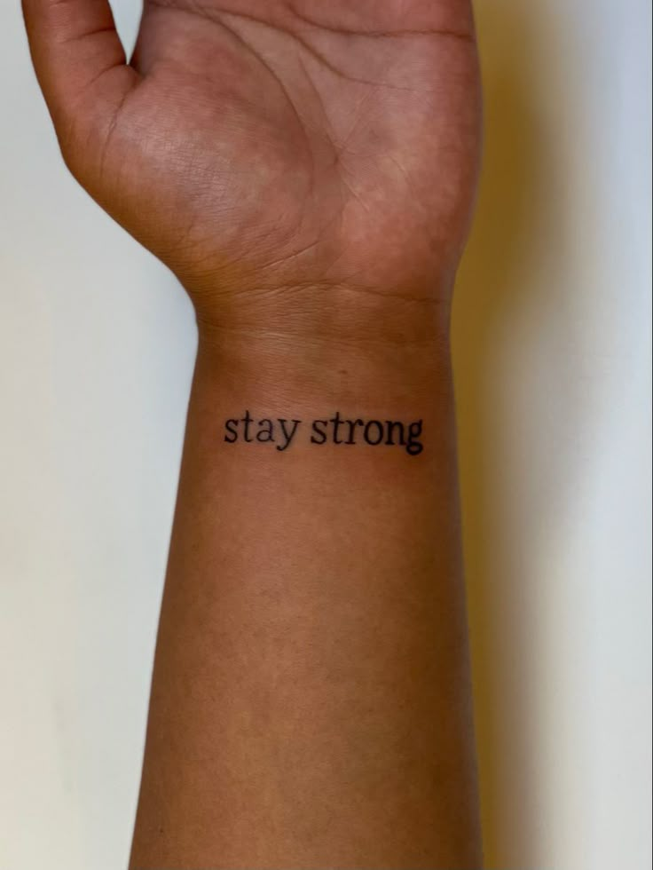 a person's arm with the words stay strong on it