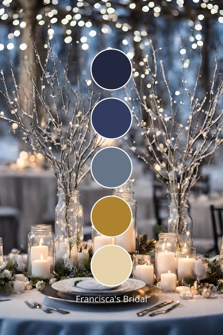 a table topped with candles and vases filled with white frosted trees covered in lights