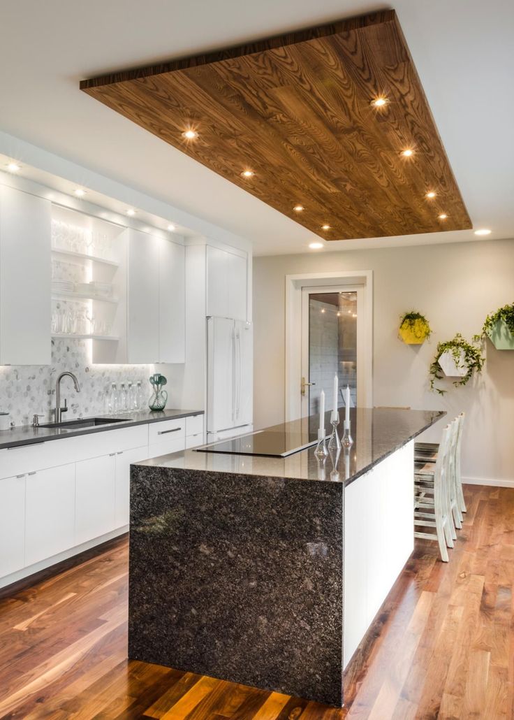 an image of a kitchen with white cabinets and black granite counter tops on the phone screen