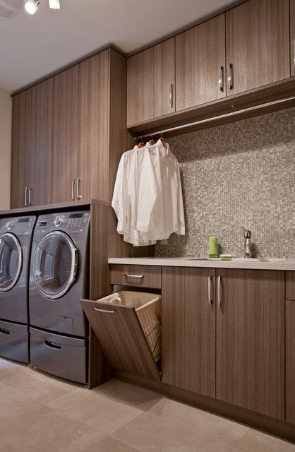 a washer and dryer in a laundry room with wooden cabinetry on the wall