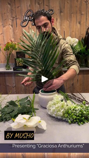 a man is arranging flowers on a table