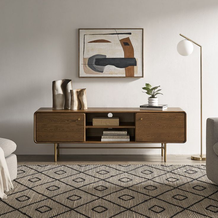 a living room with a couch, table and art on the wall above it's entertainment center