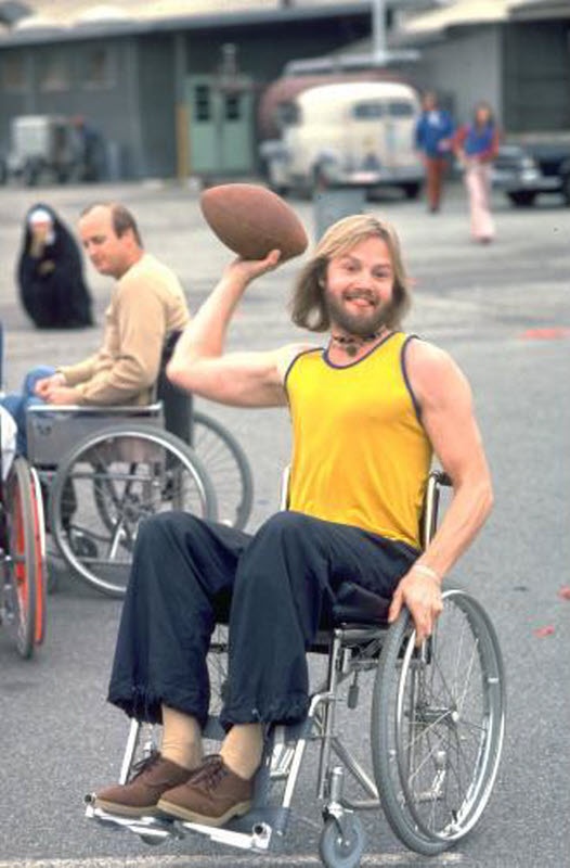 a man in a wheel chair holding a football