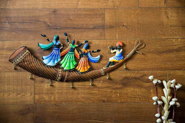 decorative wall hangings on the side of a wooden floor, depicting people in a boat