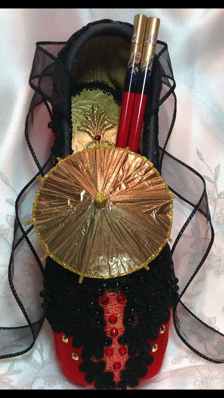 there is a small purse with an umbrella on top of it, and two lipstick brushes in the bottom