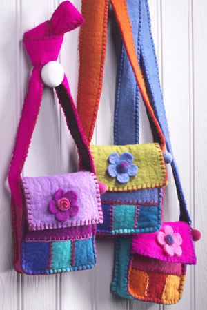 multicolored purses hanging on the wall next to each other with flower decorations