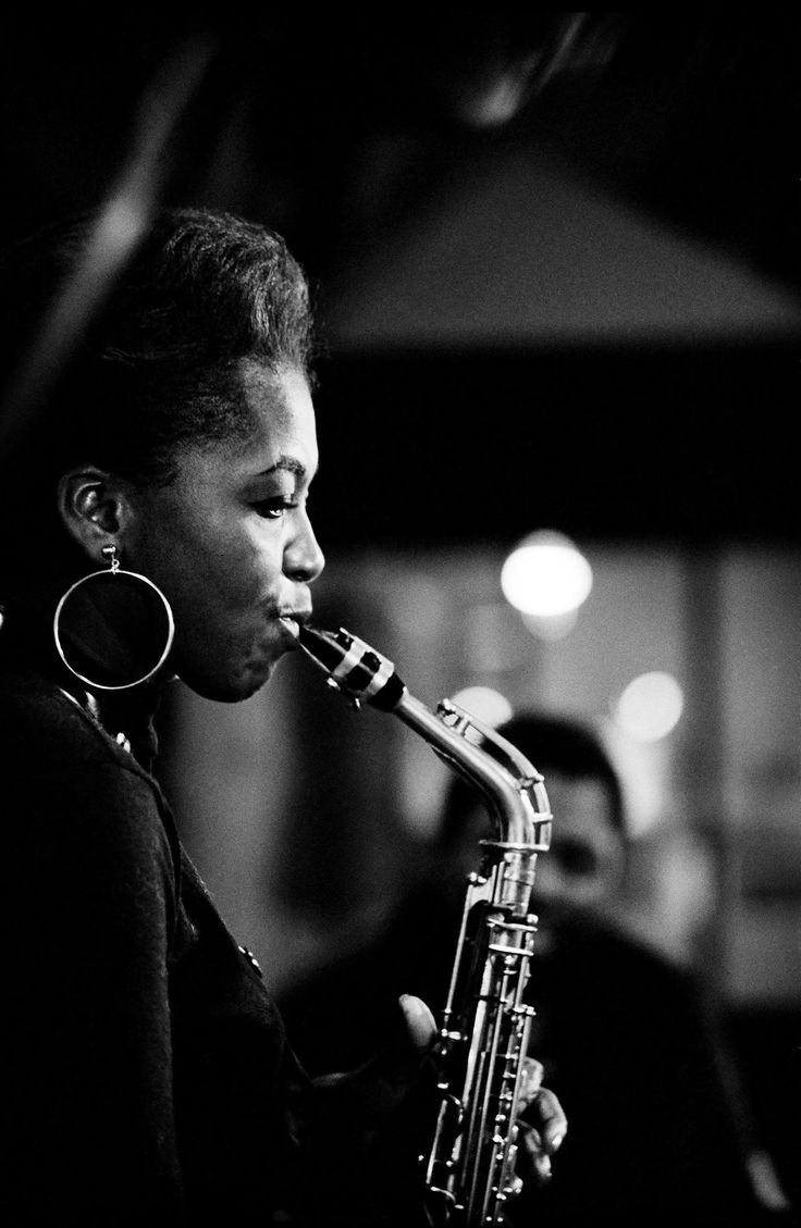 a woman playing a saxophone in a black and white photo