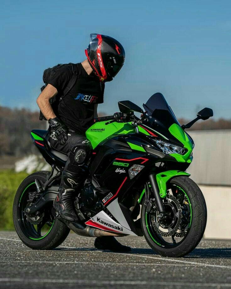 a man riding on the back of a green motorcycle