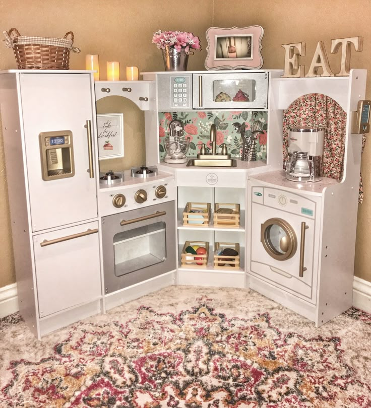 a play kitchen with lots of appliances and decor on the walls, including a rug