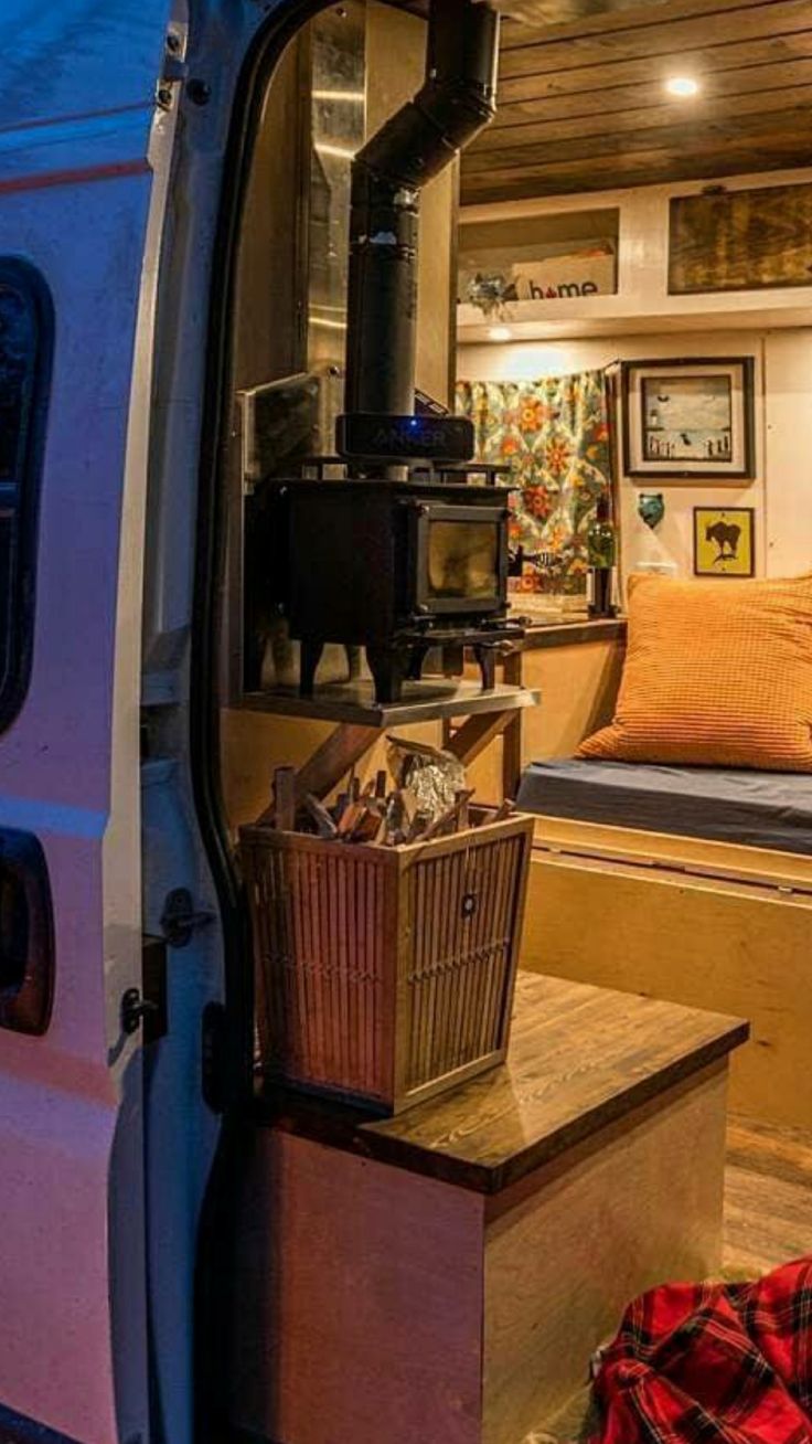 the interior of a camper van with its door open and furniture in the back