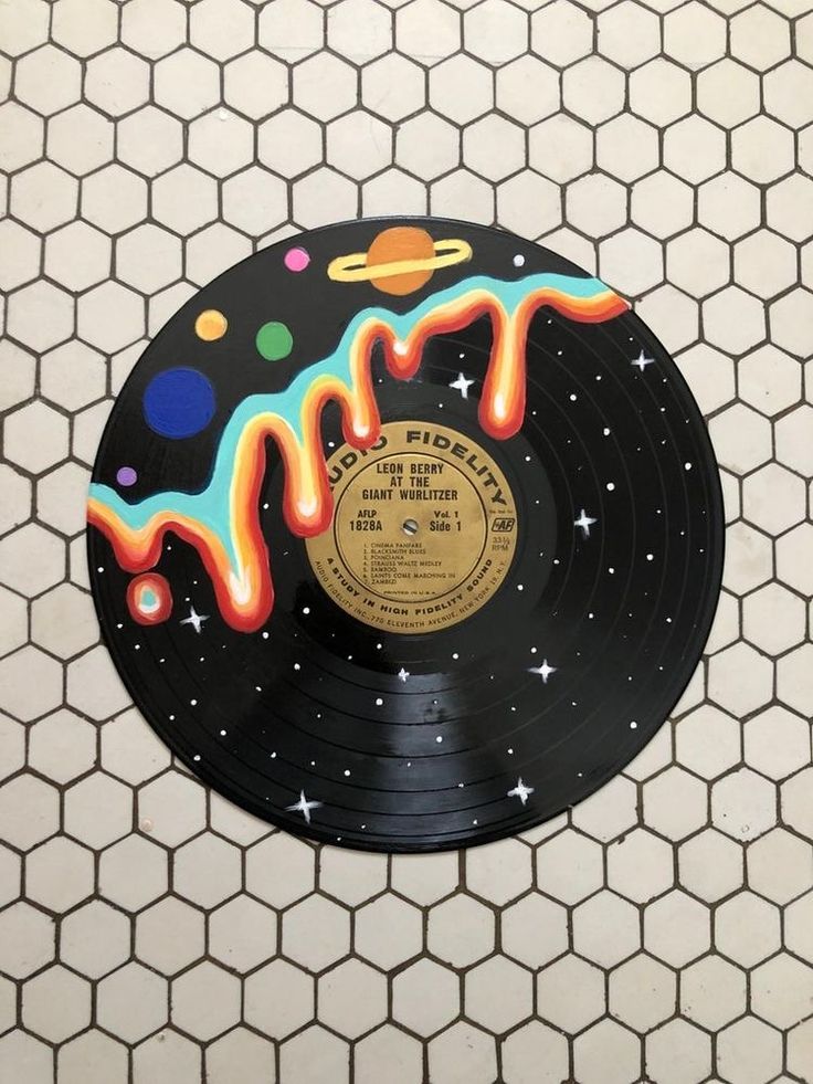 an old vinyl record with colorful sprinkles and planets painted on the side