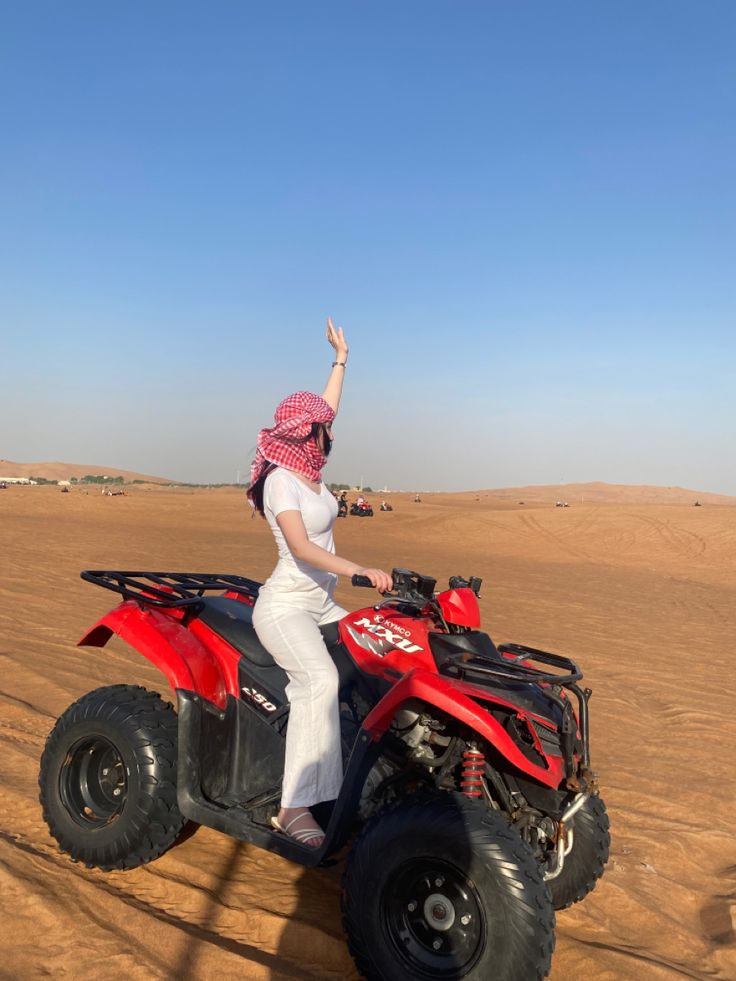 a woman riding an atv in the desert