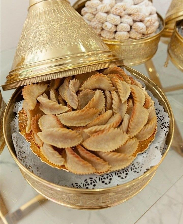 there are many desserts on the table and one is in a gold plated bowl